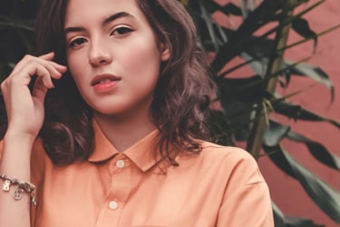 A woman in an orange shirt with a tender look